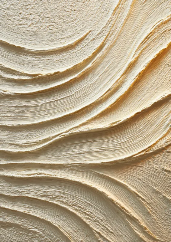 Close-up of sculpted layered cream waves in warm ivory and gold tones creating a hypnotic tactile pattern